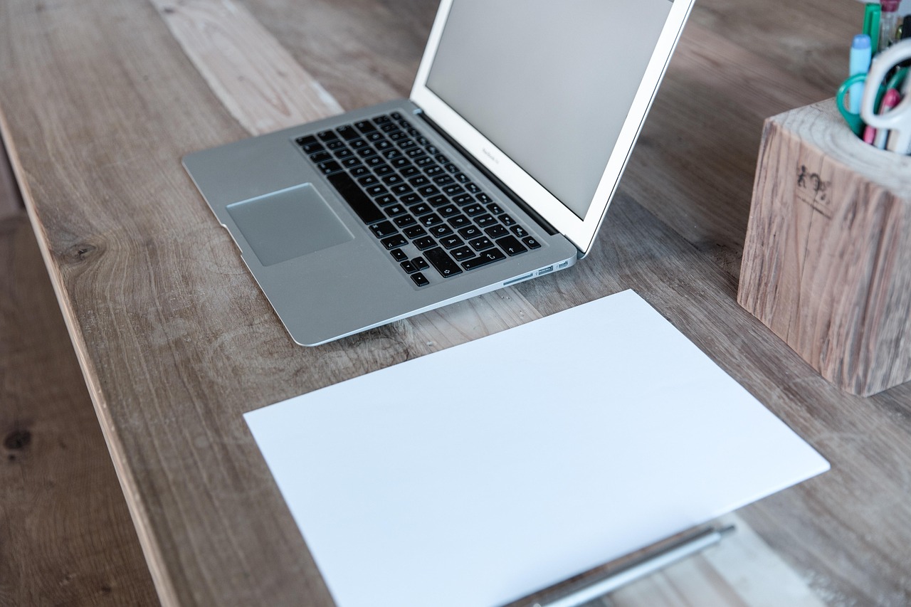a laptop and a notebook, in a clean and minimalist desk